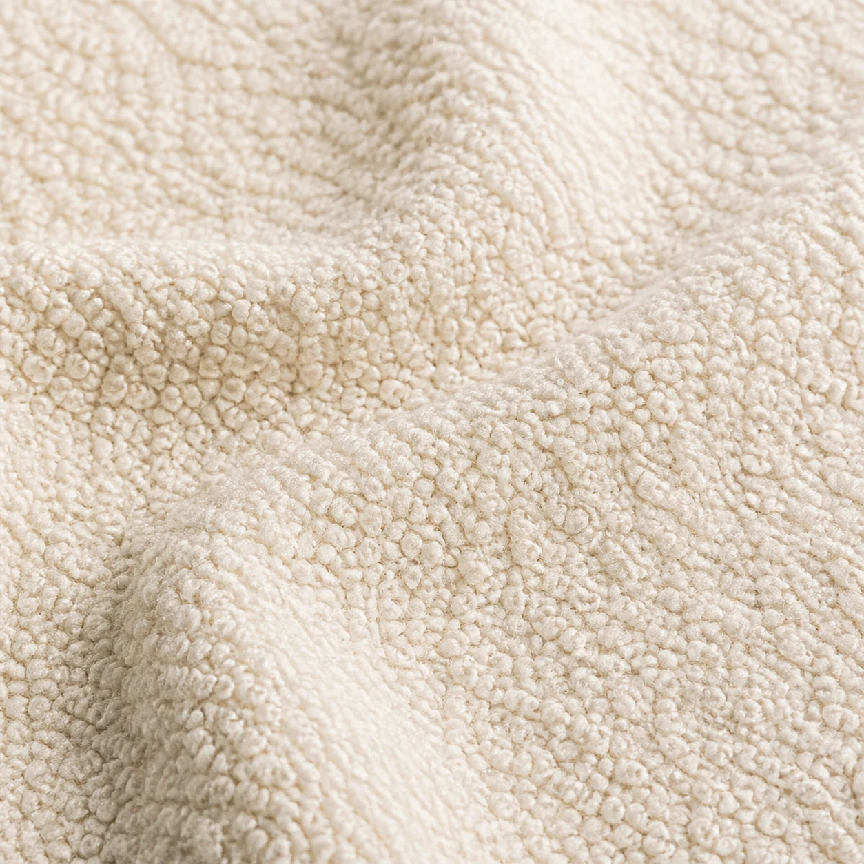 Close-up of warm off-white boucle upholstery fabric