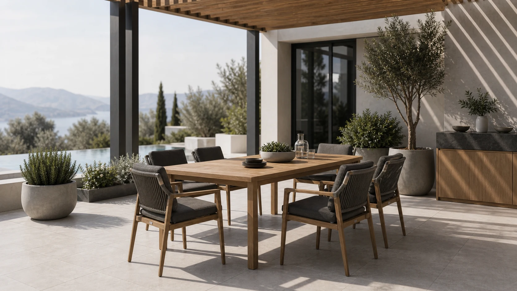 Teak outdoor dining table and woven chairs beside a pool