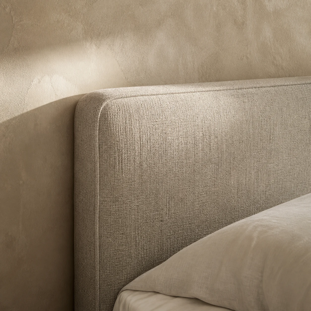 Oatmeal linen headboard with walnut nightstand and warm bedside lighting